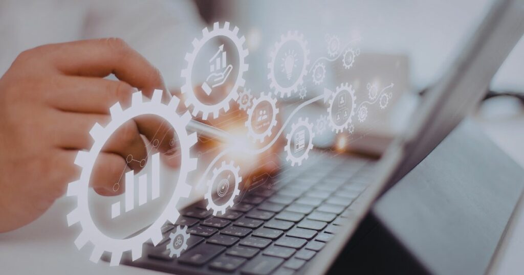 A person typing on a laptop is in the background, and digital cog graphics with charts are overlaid on top